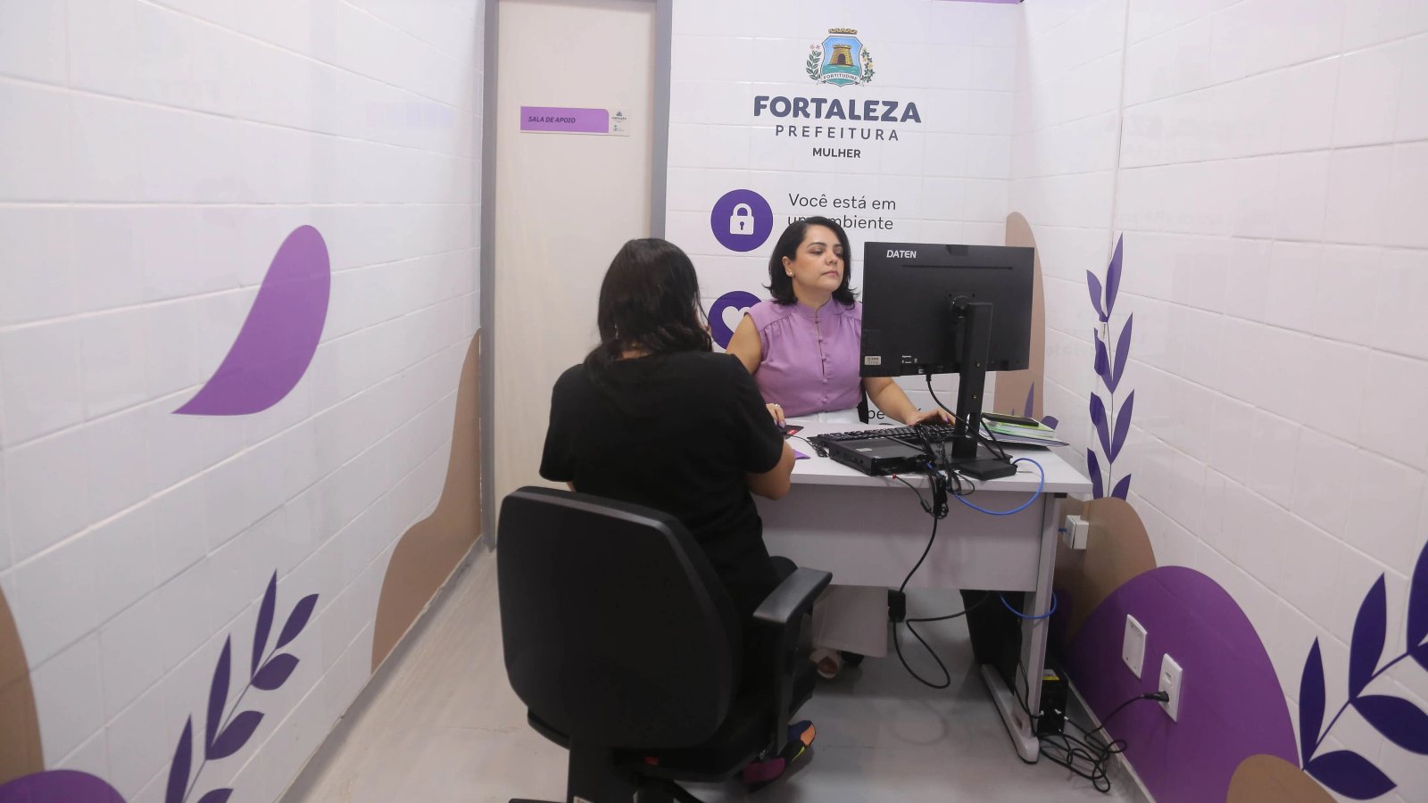 a foto mostra uma mulher de costas sendo atendida na sala lilá do IJF
